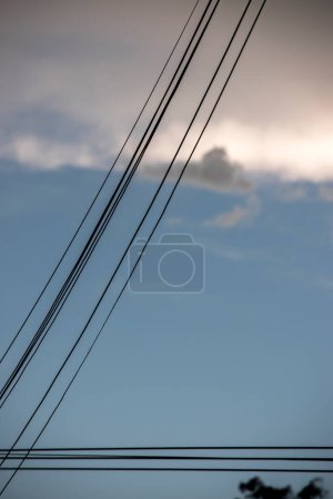 electricity cable over a blue sky with clouds
