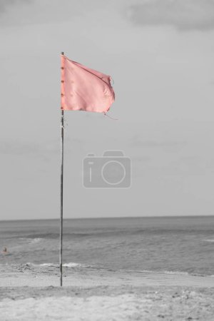 red flag on the seashore indicating bathing is prohibited