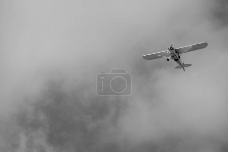 small plane doing pirouettes in the cloudy sky