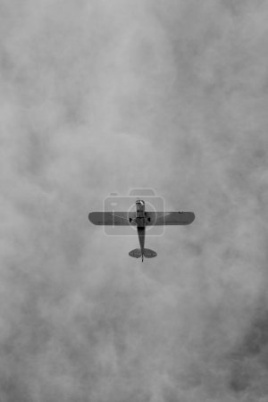 pequeño avión haciendo piruetas en el cielo nublado