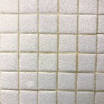 detail of the checkered pattern of an old white bathroom coverin