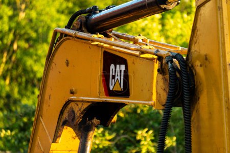 Téléchargez les photos : Berlin / Allemagne, 5 juillet 2023 : Logo CAT sur Pelle CAT Caterpillar. Tracteur avec coucher de soleil brille. terrassement, transport. concept de machines de construction. - en image libre de droit