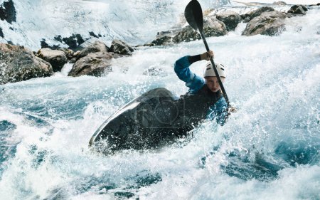 Una mujer en un kayak navega en un río de montaña. Kayak de aguas bravas,