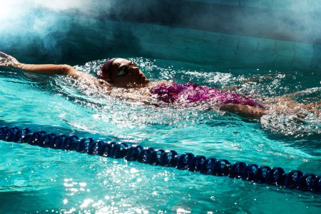 Téléchargez les photos : Une jeune nageuse qui s'entraîne dans la piscine. Nageur professionnel i - en image libre de droit