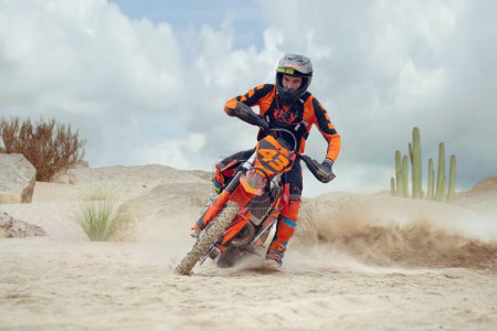 Photo for Young man practice riding dirt motorcycle. Splashing sand - Royalty Free Image