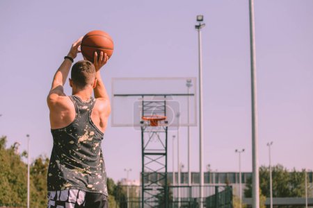 Téléchargez les photos : Joueur de basket masculin jetant la balle dans l'anneau - en image libre de droit