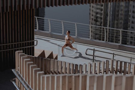 Téléchargez les photos : Jeune femme fait de l'exercice en plein air au milieu de la ville - en image libre de droit