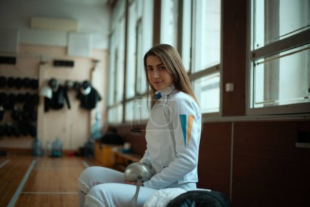 Photo for Fencing sport. Beauty female fencer training in hall. - Royalty Free Image