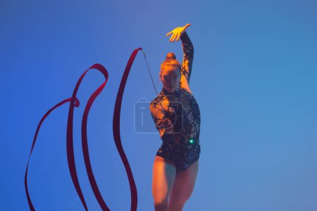 Téléchargez les photos : Gymnastique rythmique en action. Femme gymnaste rythmique dansant en studio. - en image libre de droit