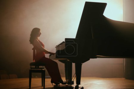 Foto de La mujer tocando el piano en la sala de conciertos - Imagen libre de derechos