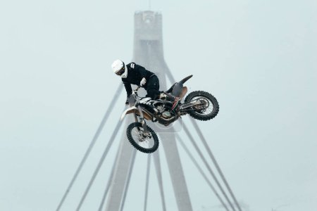 Photo for Man performing a great trick for beginner FMX rider - Royalty Free Image