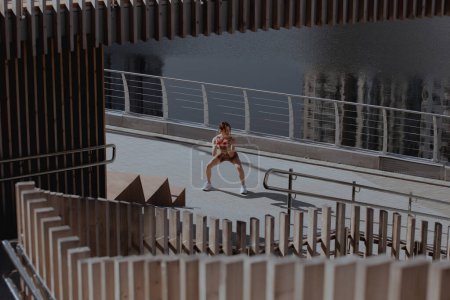 Téléchargez les photos : Jeune femme fait de l'exercice en plein air au milieu de la ville - en image libre de droit