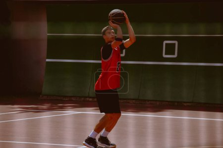 Foto de Jugador de baloncesto masculino jugando streetball durante el día caliente - Imagen libre de derechos