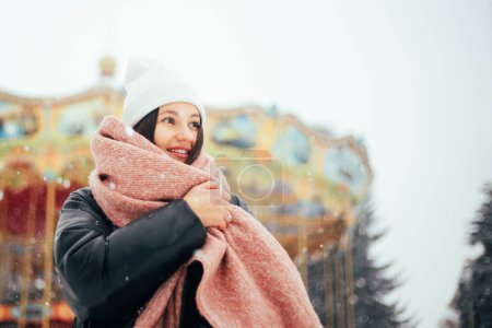 Foto de Mujer morena joven en sombrero de invierno blanco caminando parque nevado - Imagen libre de derechos