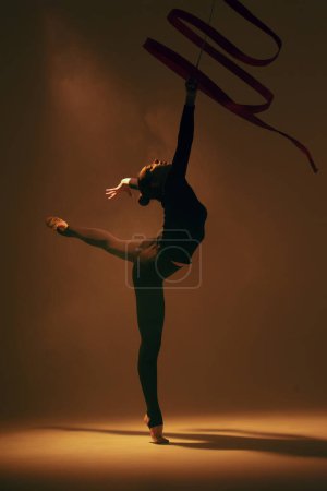 Téléchargez les photos : Gymnastique rythmique en action. Femme gymnaste rythmique dansant en studio. - en image libre de droit