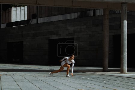 Téléchargez les photos : Fille sportive performant avec un entraînement fonctionnel dans la rue. - en image libre de droit