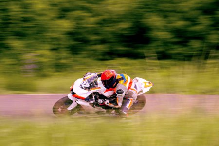 Foto de Un corredor de motocicletas está conduciendo rápido en una pista de motocicletas. - Imagen libre de derechos