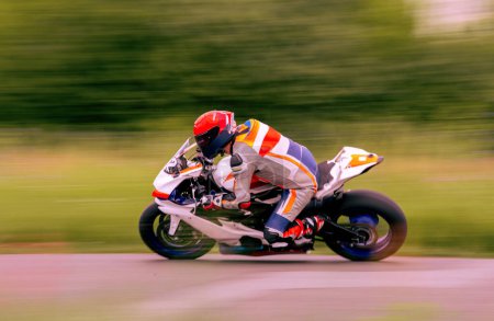Foto de Un corredor de motocicletas está conduciendo rápido en una pista de motocicletas. - Imagen libre de derechos