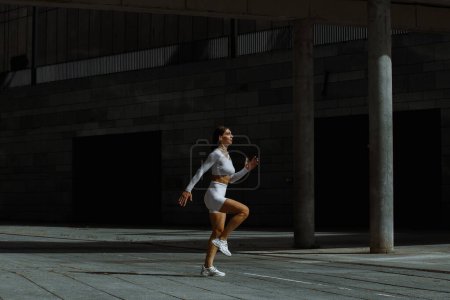 Téléchargez les photos : Fille sportive performant avec un entraînement fonctionnel dans la rue. - en image libre de droit