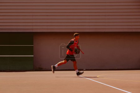 Photo for Male basketball player playing streetball during hot day - Royalty Free Image