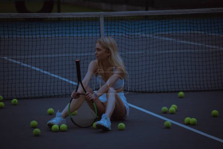 Téléchargez les photos : Femme joueuse de tennis assise sur le court de tennis - en image libre de droit