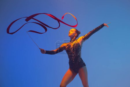 Foto de Gimnasia rítmica en acción. Mujer gimnasta rítmica bailando en estudio. - Imagen libre de derechos