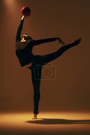 Foto de Gimnasia rítmica en acción. Mujer gimnasta rítmica bailando en estudio. - Imagen libre de derechos