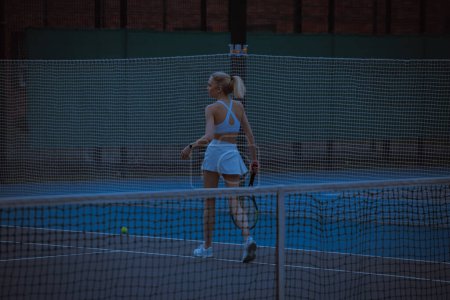 Photo for Woman tennis player trains on the tennis court - Royalty Free Image