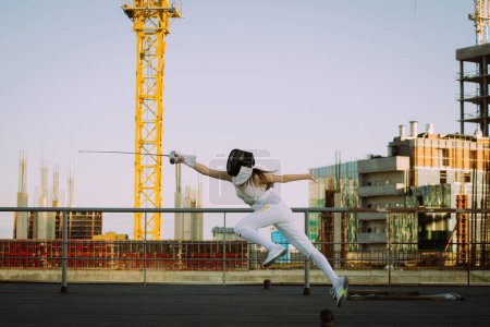 Fencer woman practice on a rooftop with the city in background 