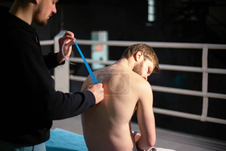Téléchargez les photos : Massothérapeute sportif effectuant massage et enregistrement - en image libre de droit