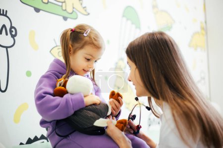 Photo for Pediatrician checking up girl child in clinic - Royalty Free Image