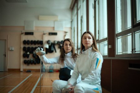 Photo for Fencing sport. Two girl fencers posing in hall. - Royalty Free Image