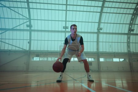 Téléchargez les photos : Jeune joueur jouant au basket sur le terrain - en image libre de droit
