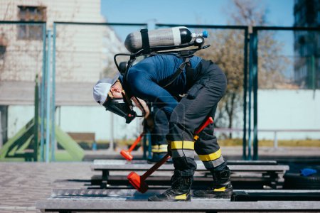 Photo for Firefighters in protection masks  training on the sports ground. - Royalty Free Image