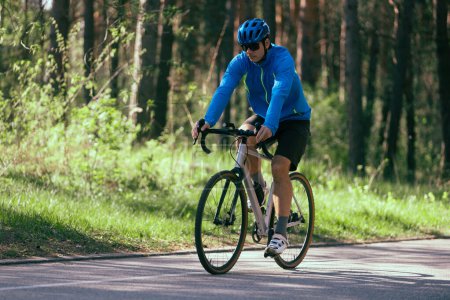 Téléchargez les photos : Homme cycliste à vélo sur la route forestière - en image libre de droit