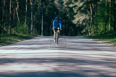 Foto de Joven montar en bicicleta por carretera en el bosque - Imagen libre de derechos