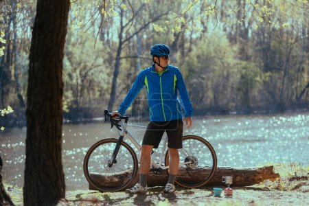 Téléchargez les photos : Jeune homme à vélo sur la route en forêt - en image libre de droit