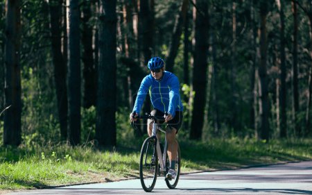 Téléchargez les photos : Jeune homme cycliste à vélo en forêt. - en image libre de droit