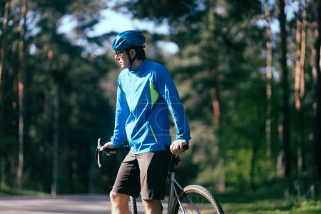 Téléchargez les photos : Jeune cycliste professionnel dans une forêt sur fond de nature - en image libre de droit