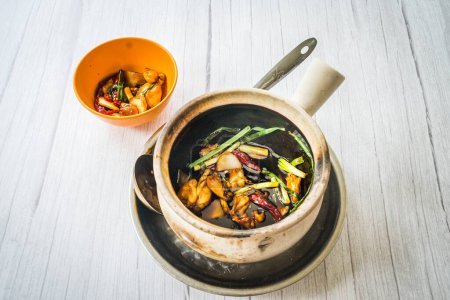 Photo for Stir fry frog leg with spring onions and dried reed chilli and served in a claypot - Royalty Free Image