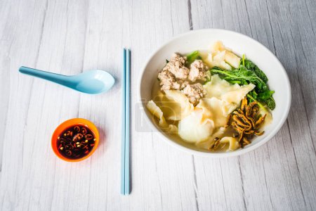 Photo for Chinese pasta flour sheets mee hoon kway in soup broth with minced pork, egg, fried anchovies, spinach - Royalty Free Image