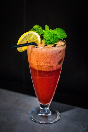 Photo for A cold beverage of Strawberry Lemon Mint served in a tall glass with mint leaves and lemon - Royalty Free Image