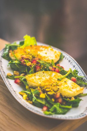 Photo for A serving of Grilled Cheese Halloumi cheese served with arugula, pomegranate - Royalty Free Image