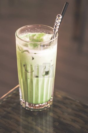 Photo for Matcha green tea latte served in a tall glass with ice and a straw - Royalty Free Image