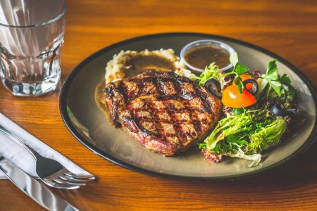 Photo for Ribeye steak with Mashed potato and gravy, mesclun salad and mushroom sauce - Royalty Free Image