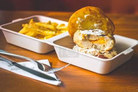 Photo for Cheese Stuffed Pork Burger with Cheesy stuffed patty and served with coleslaw and french fries - Royalty Free Image