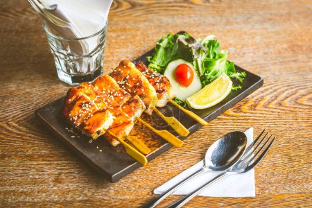 Photo for Grilled salmon belly skewer with teriyaki sauce and sesame seeds with salad on the side - Royalty Free Image
