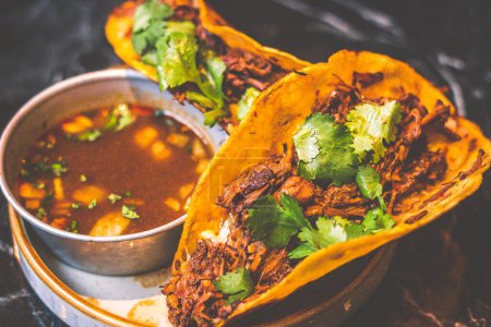 Photo for Beefy Birria Tacos made using 8 hour slow cooked chuck with beef consomme on the side - Royalty Free Image