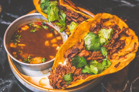 Beefy Birria Tacos made using 8 hour slow cooked chuck with beef consomme on the side