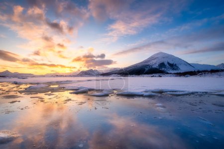 Photo for North, Norway. Winter landscape during sunset. Bright sky. Ice and snow on the shore. Reflections on the ice surface. Snowy winter. Natural northern landscape on the Lofoten Islands. - Royalty Free Image